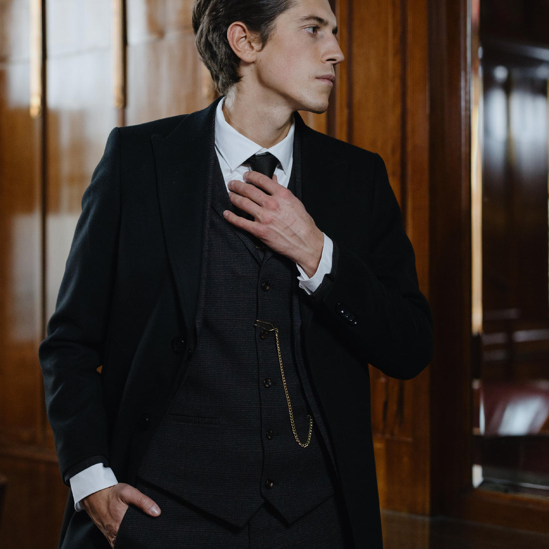 man wearing a formal black suit with a white shirt and long black neck tie